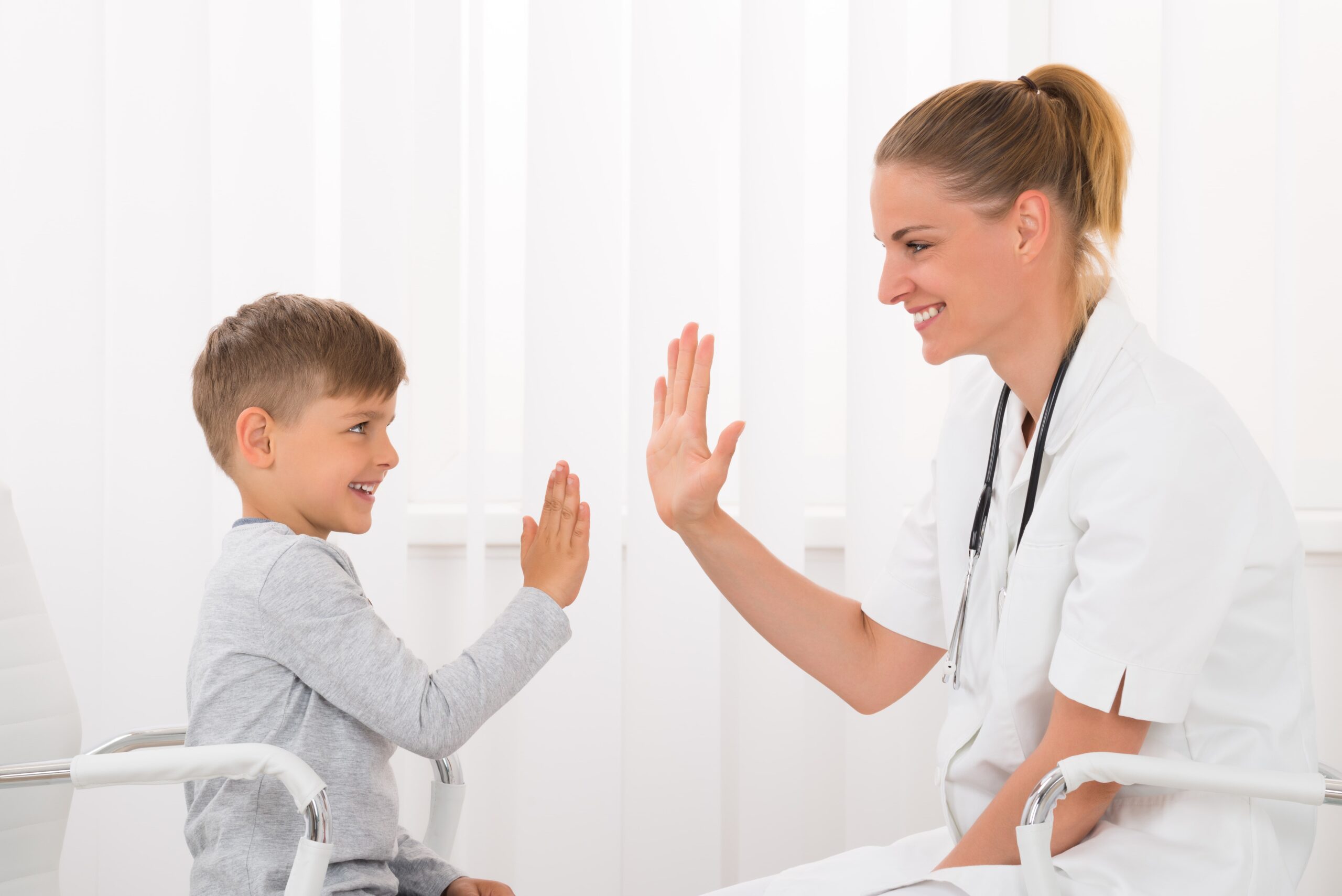 Arts die kindje een high five geeft
